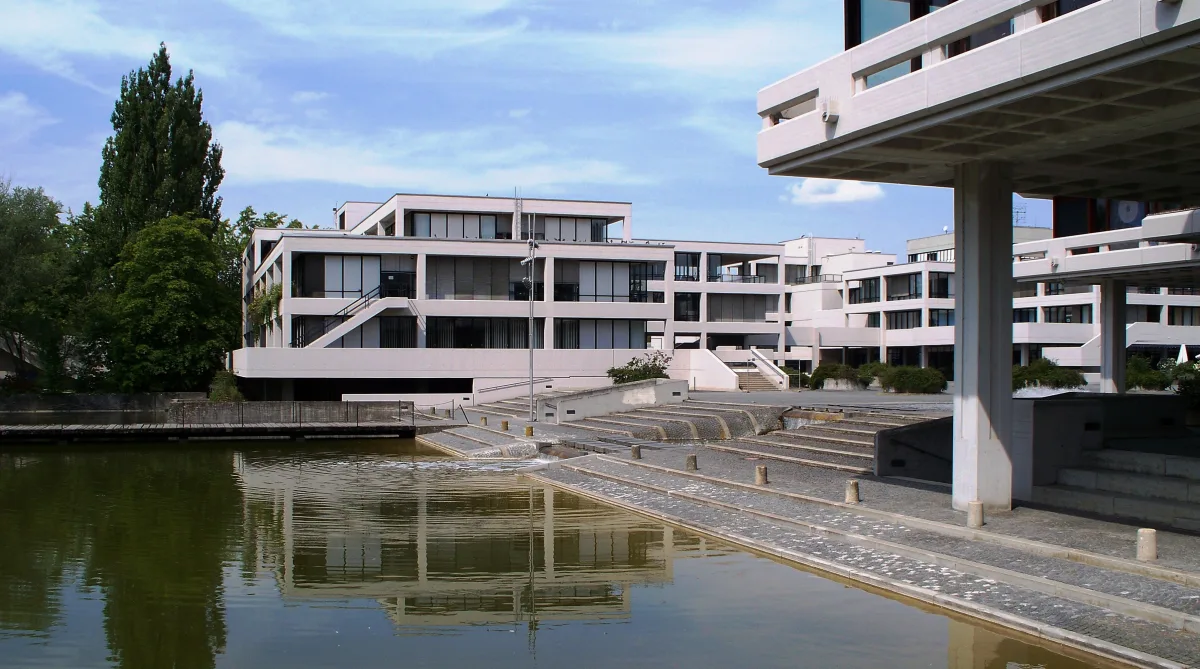 Regensburg Üniversitesi kampüsündeki gölet ve çevresindeki binalar